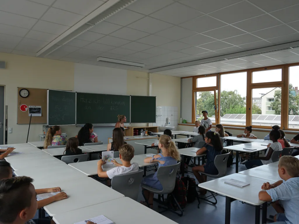 Blick über die Tische auf die Tafel.
